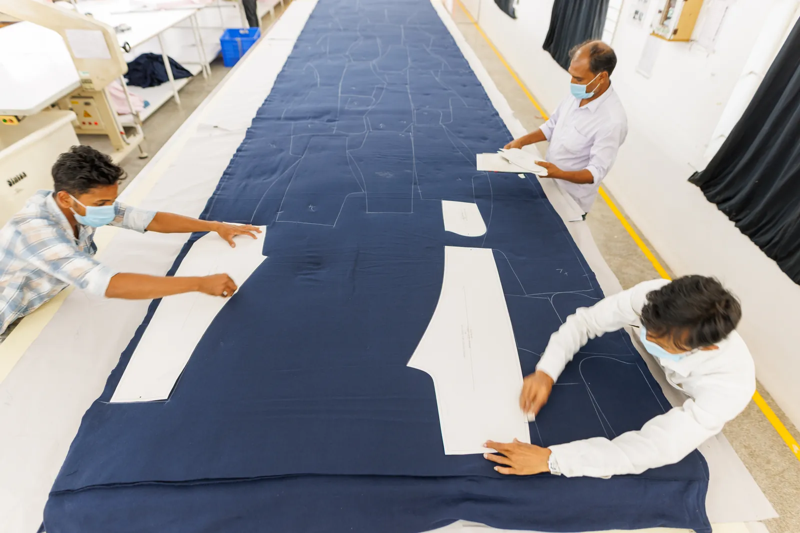 Cut garment panels being checked against the approved pattern