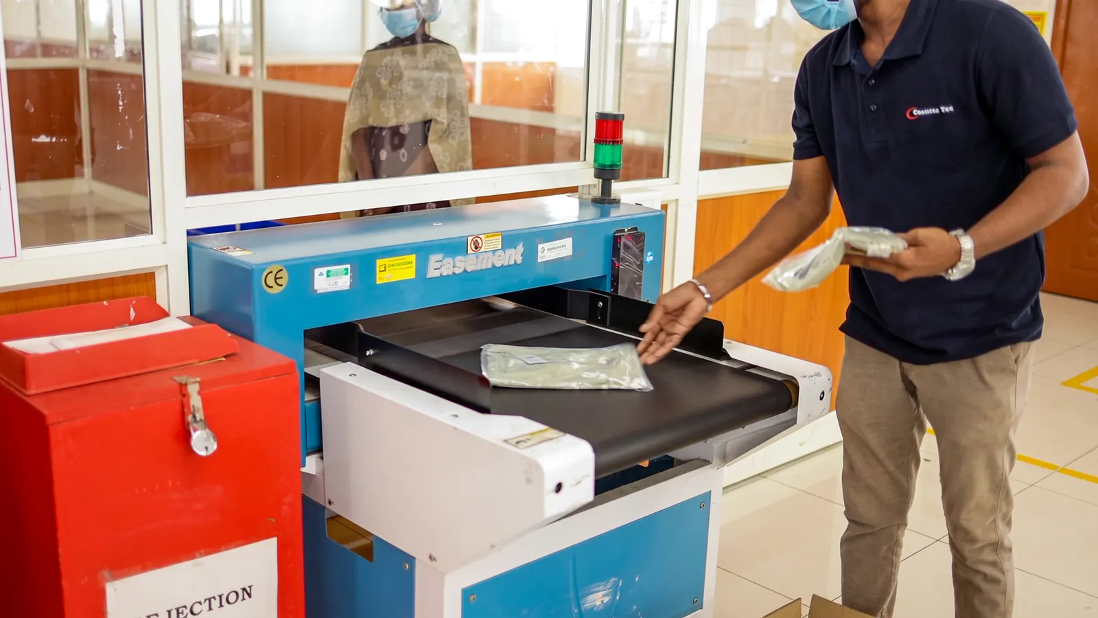A packaged garment passing through needle detection equipment